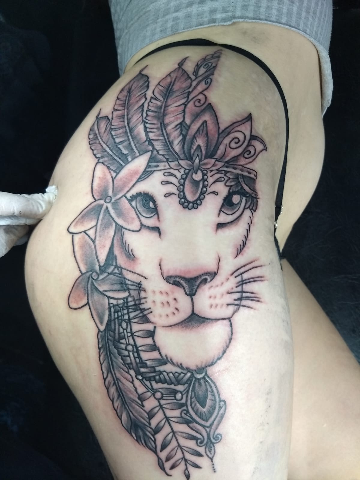 Tatuaje de león con tocado de plumas